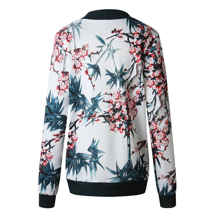 Back product view of the white botanical jacket with dark ribbed trim, showing flowering branches and foliage on plain white.