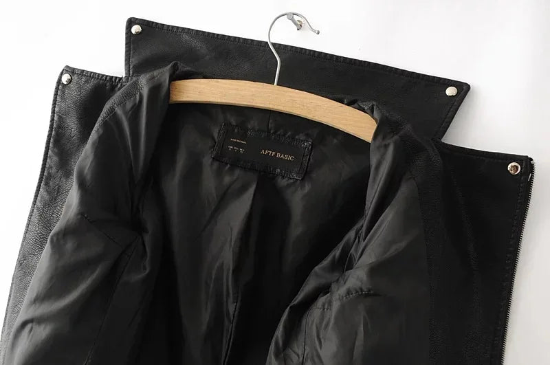 Black jacket interior view beneath an open collar, with the hanger, lining, shoulder tabs and snap details visible at the top