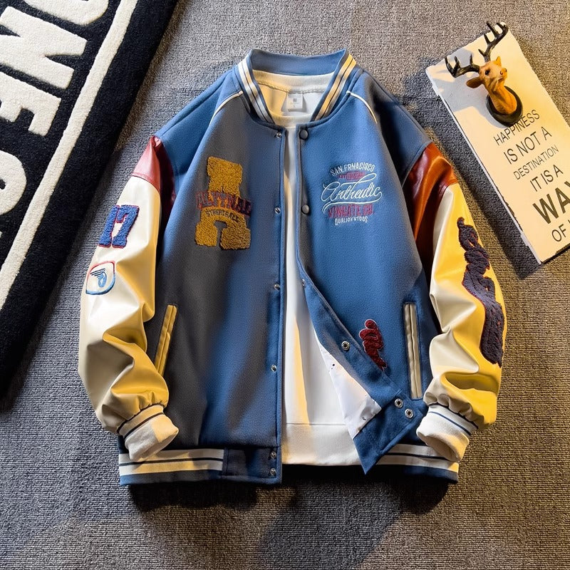 WT167 jacket in Blue shown in a front product view, showing contrast sleeves and embroidery, against a gray textile backdrop.