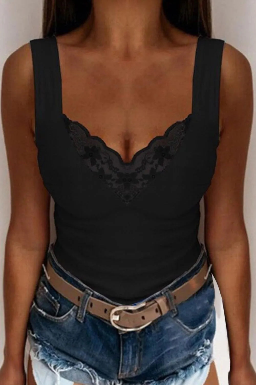 Plus size model wearing sleeveless lace top outdoors

