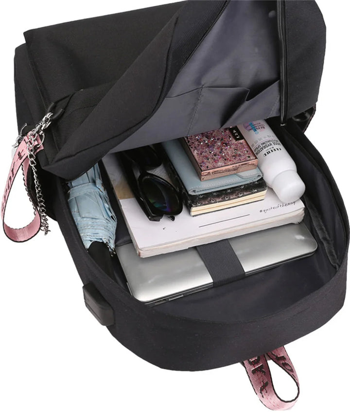 Open interior reference with books, a bottle and other packed items in the black bag; the displayed items are supplier props.