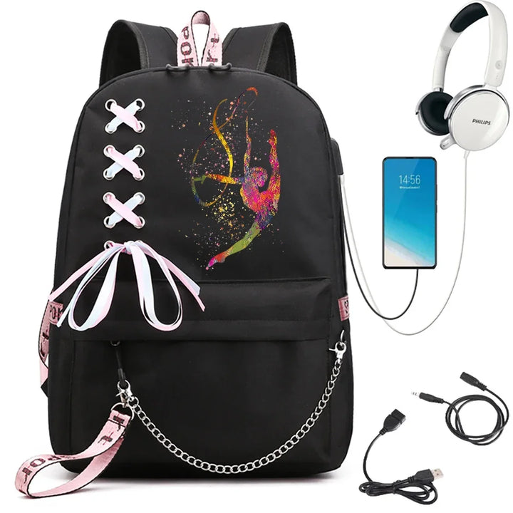 A black school backpack with an inverted gymnast print in warm colors, pale ribbon bow and chain, beside demonstration props.