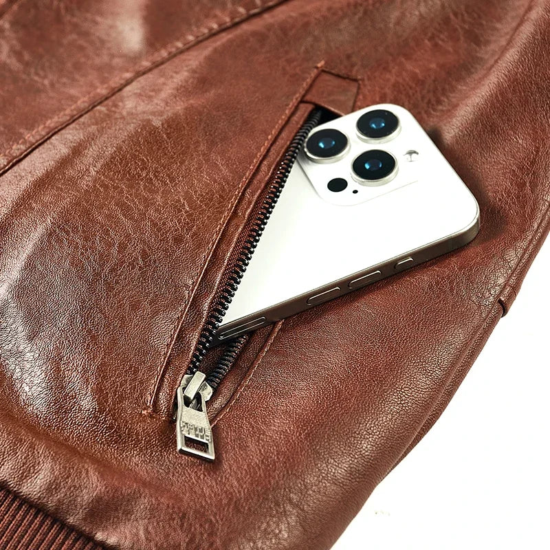 Brown jacket diagonal zip pocket detail, shown with a phone at the pocket opening.