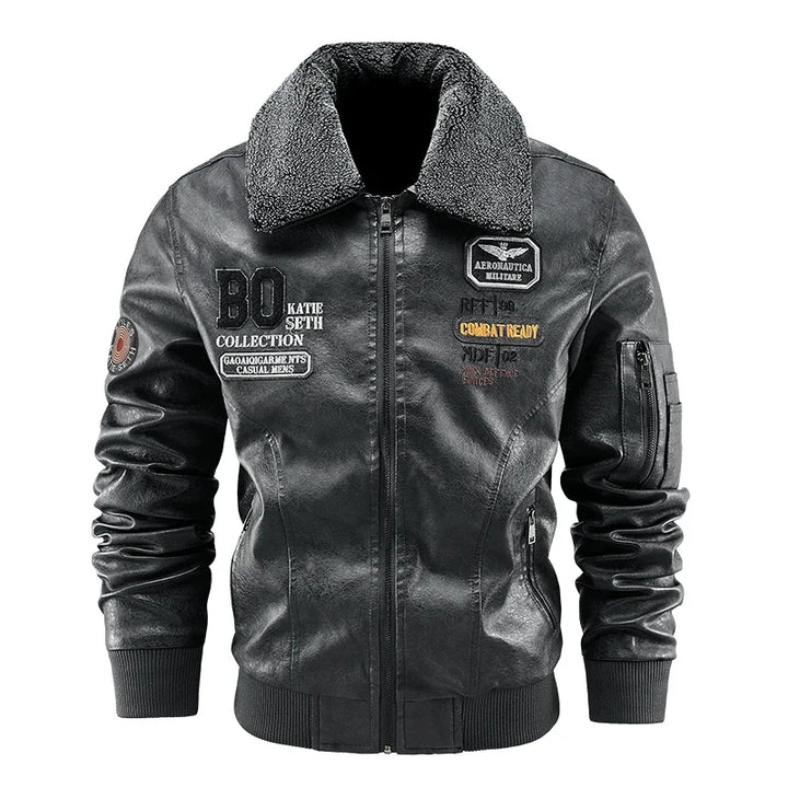 Gray jacket front view showing the textured collar, chest lettering, sleeve zip pocket and ribbed hem.