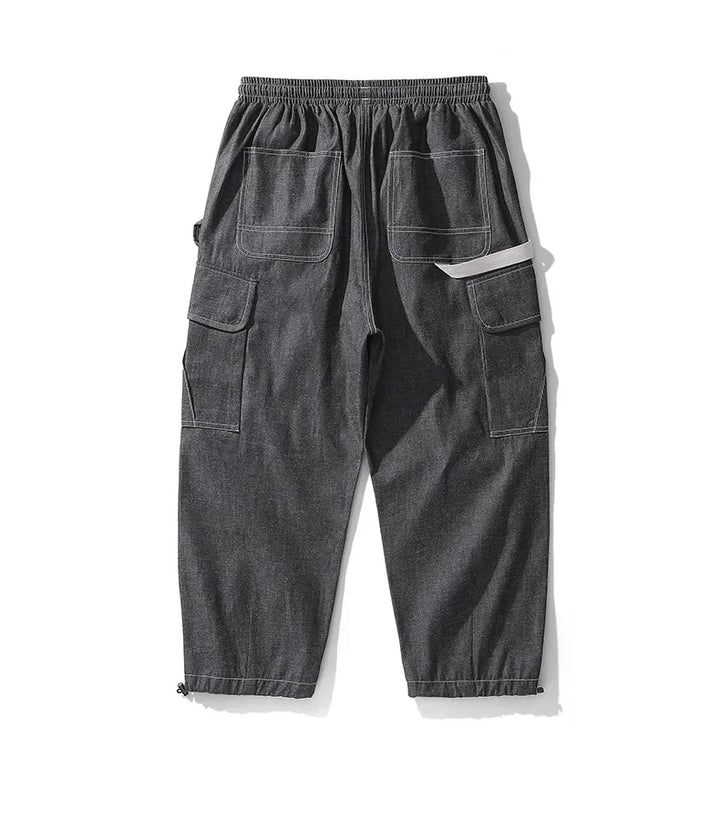 Original back view of black cargo joggers with rear patch pockets and a cream side loop.