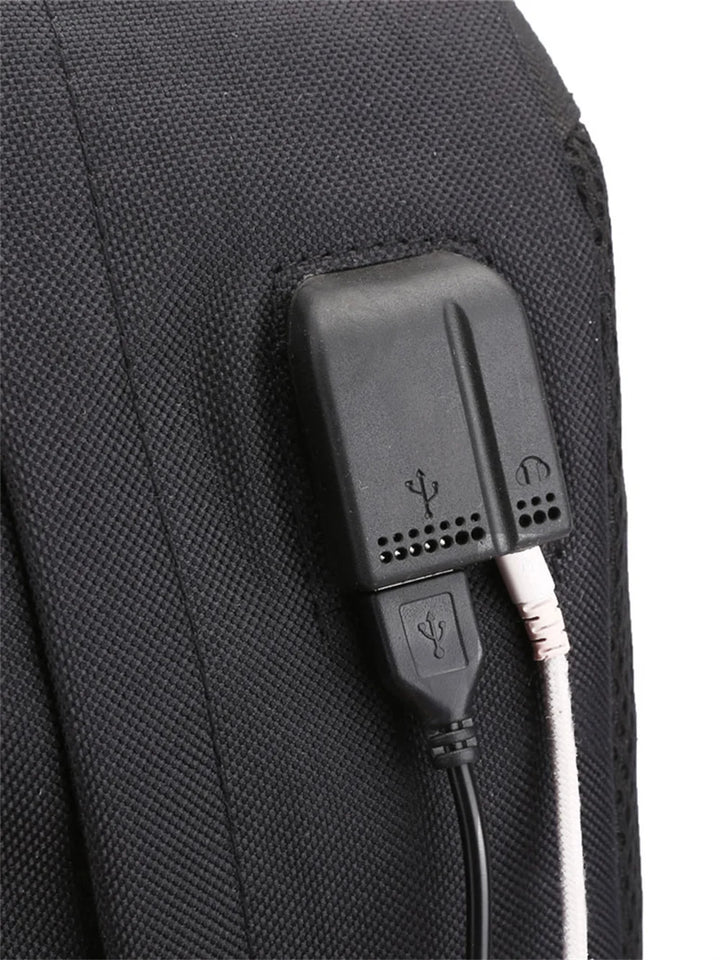 Close-up of the backpack connection panel with USB and headphone symbols, showing two plugged-in cable examples in the photo.