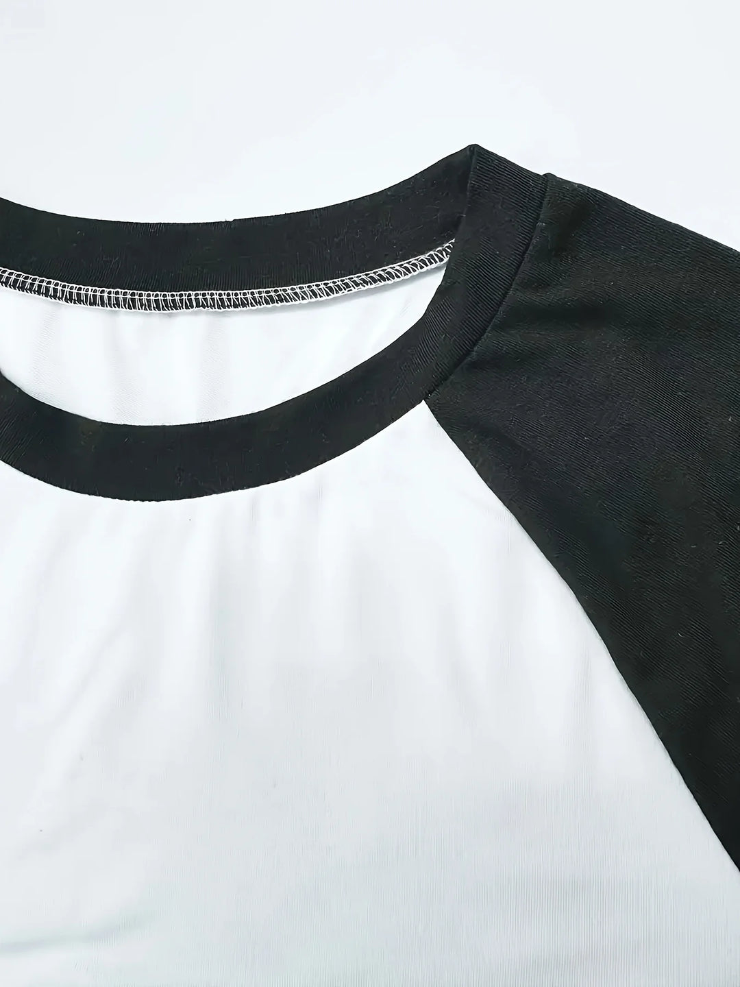Original detail photo of the black neckline and raglan seam