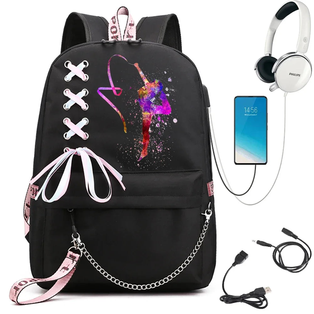 A black backpack with bright hoop gymnast artwork, light pink ribbon bow, pink webbing and chain, beside demonstration props.