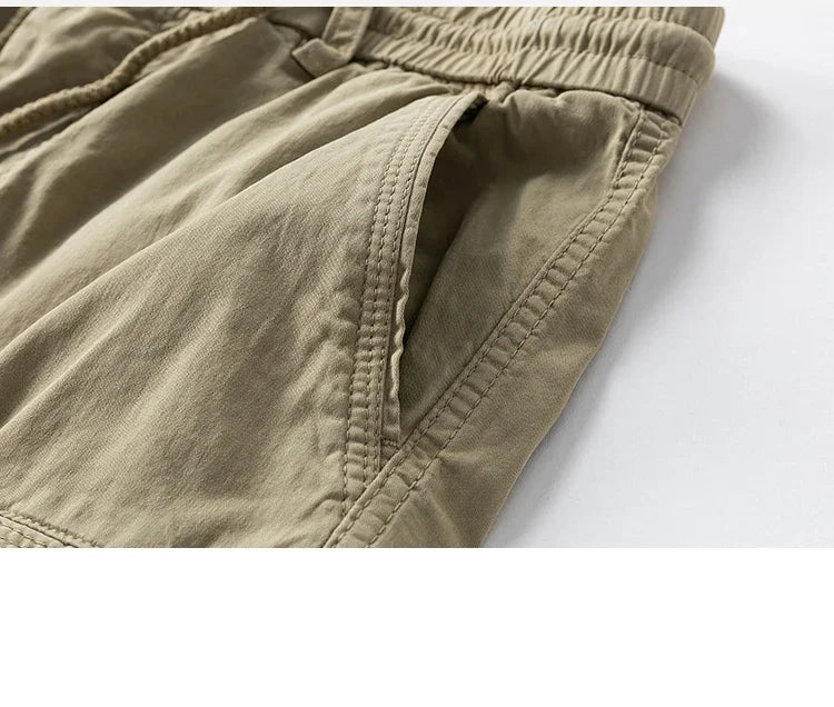 Original close-up of a khaki cargo shorts side pocket and seam stitching.