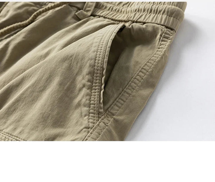 Original close-up of a khaki cargo shorts side pocket and seam stitching.