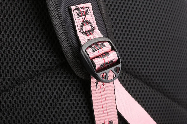 Close view of the shoulder strap adjustment buckle, black padding and pink webbing on the backpack in the supplier reference.