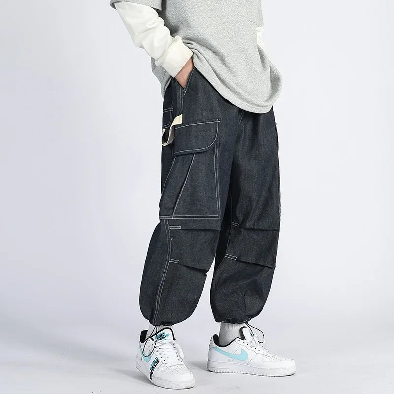Original navy blue cargo joggers shown on a model with contrast stitching and cinched ankles.