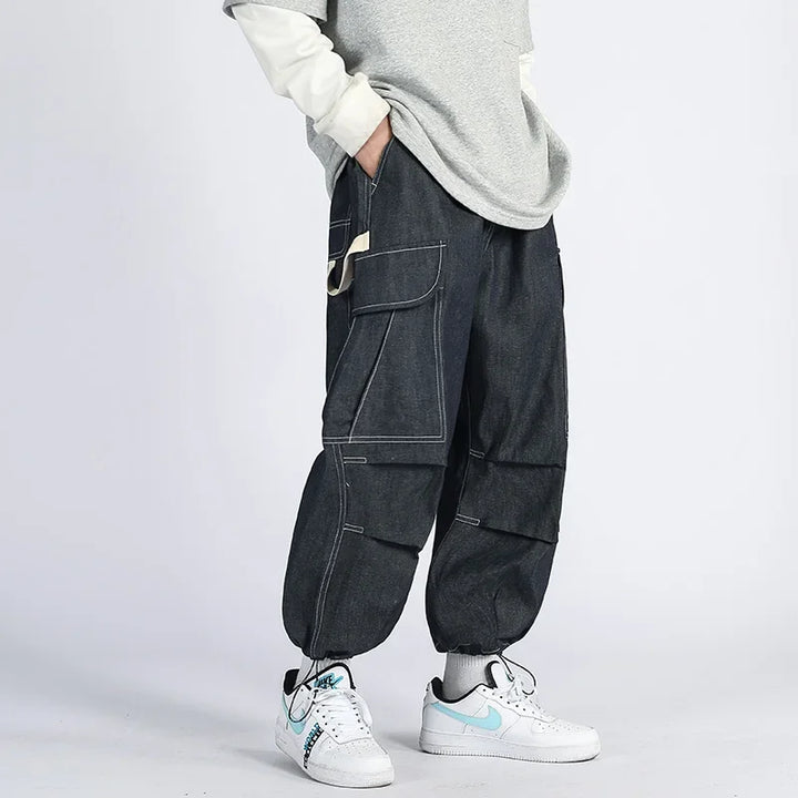 Original navy blue cargo joggers shown on a model with contrast stitching and cinched ankles.