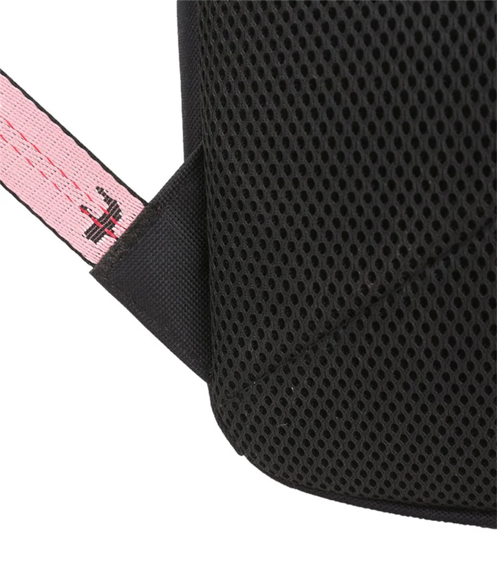 Close view of the black mesh back panel on the backpack, with the visible surface texture and the edge of a pink woven strap.
