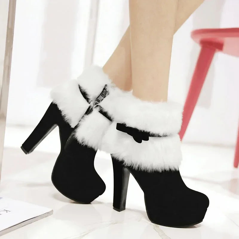 Black boots worn in a seated styling view, showing white fluffy cuffs, black side bows, and high heels beside a studio chair.