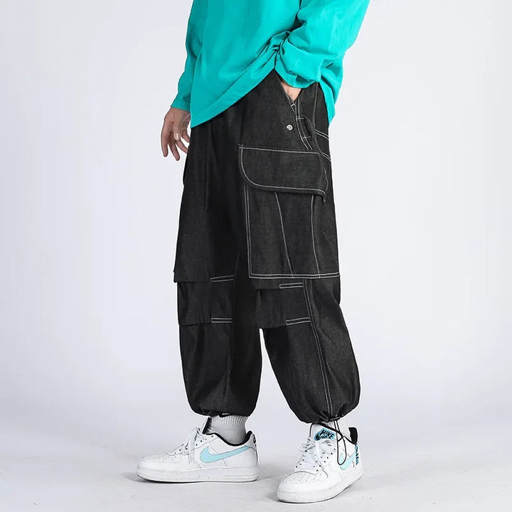 Original black cargo joggers shown on a model with large thigh pockets and cinched ankles.