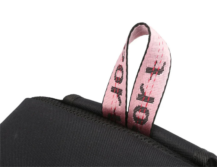 Close view of the pink top handle and black fabric seams on the backpack, photographed in the original supplier detail image.