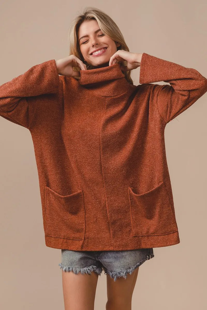 Side view: tailoring and stretch of the Rib Double Pocket Turtle Neck Top in oatmeal

