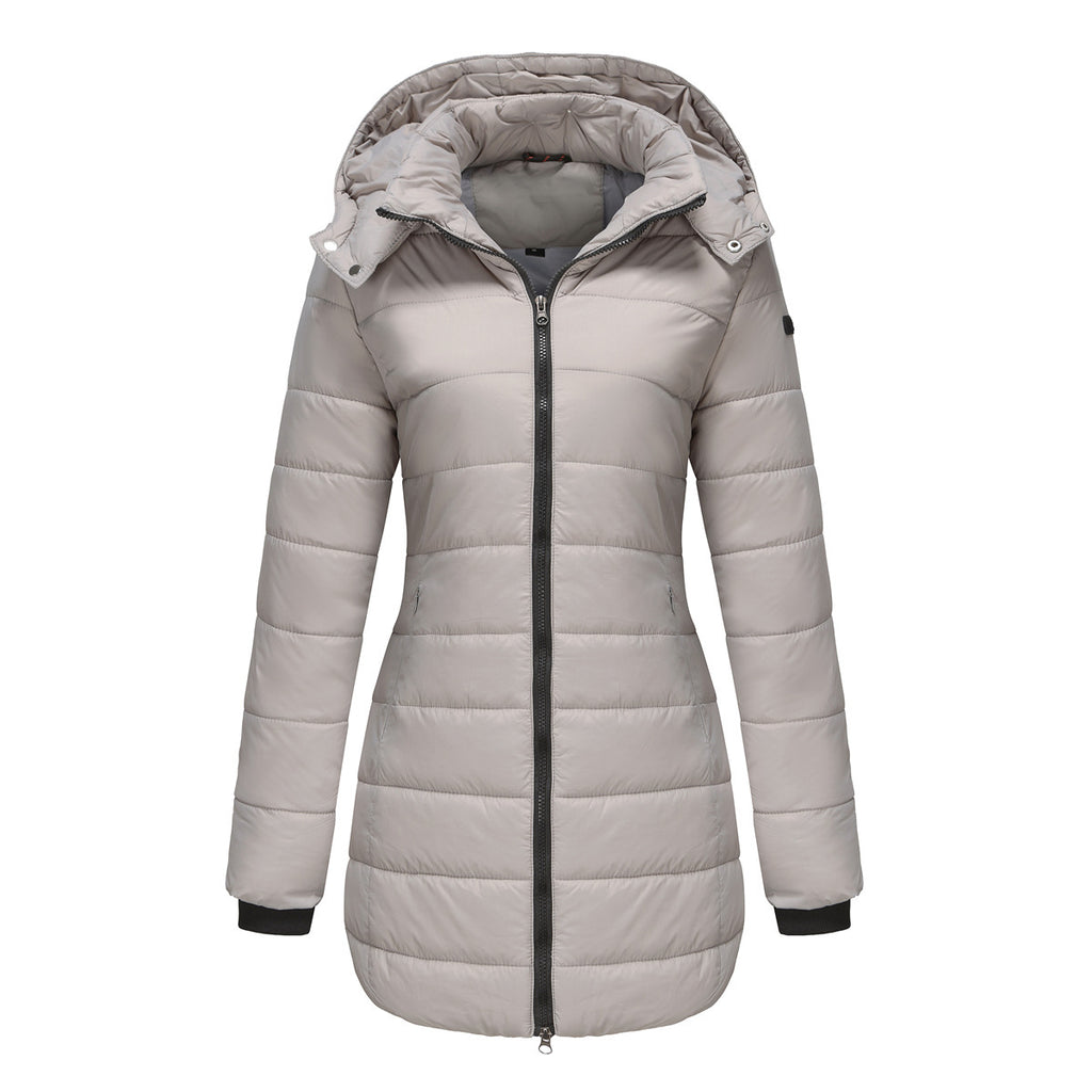 Hiker in olive green waterproof cotton-padded jacket trekking through misty mountains

