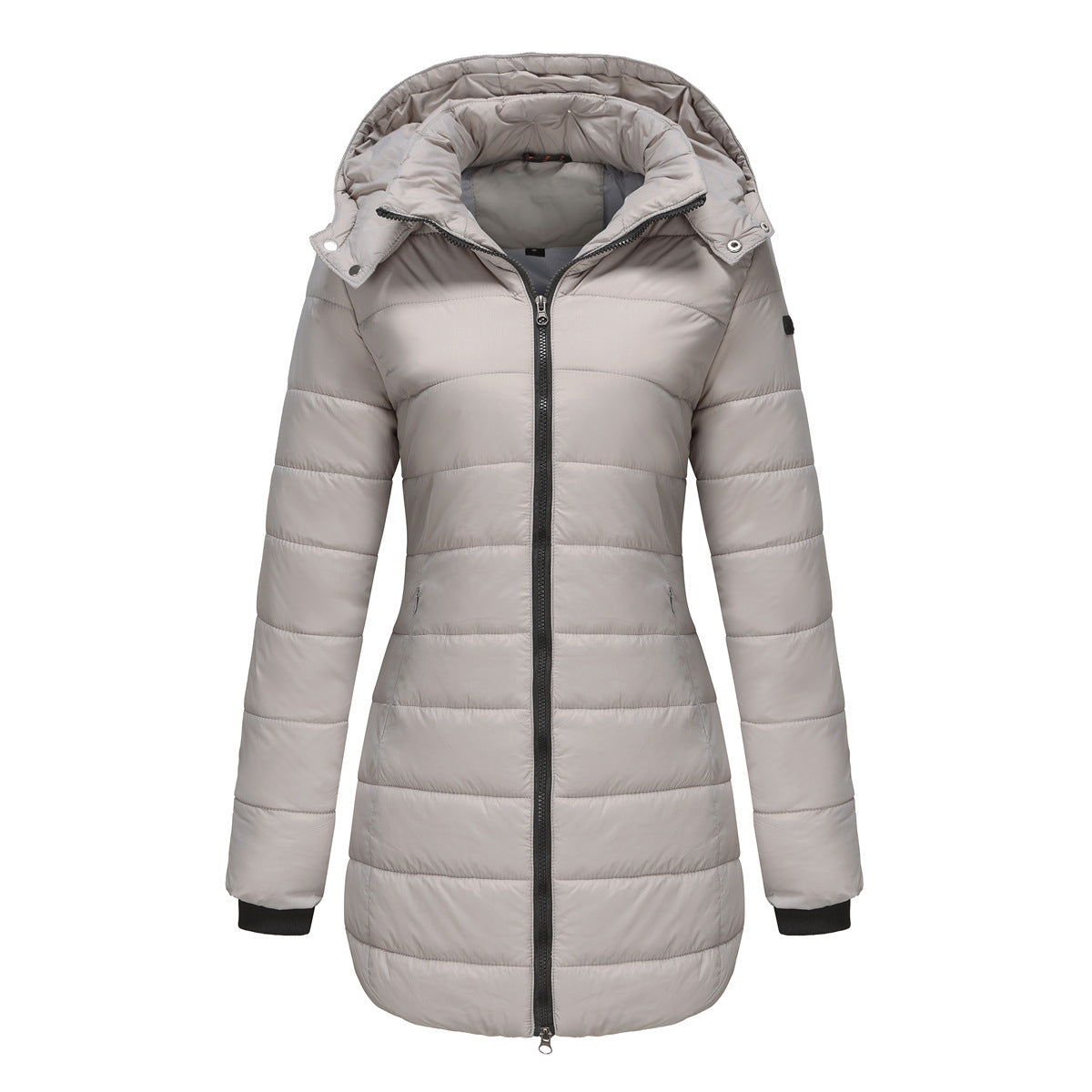Hiker in olive green waterproof cotton-padded jacket trekking through misty mountains

