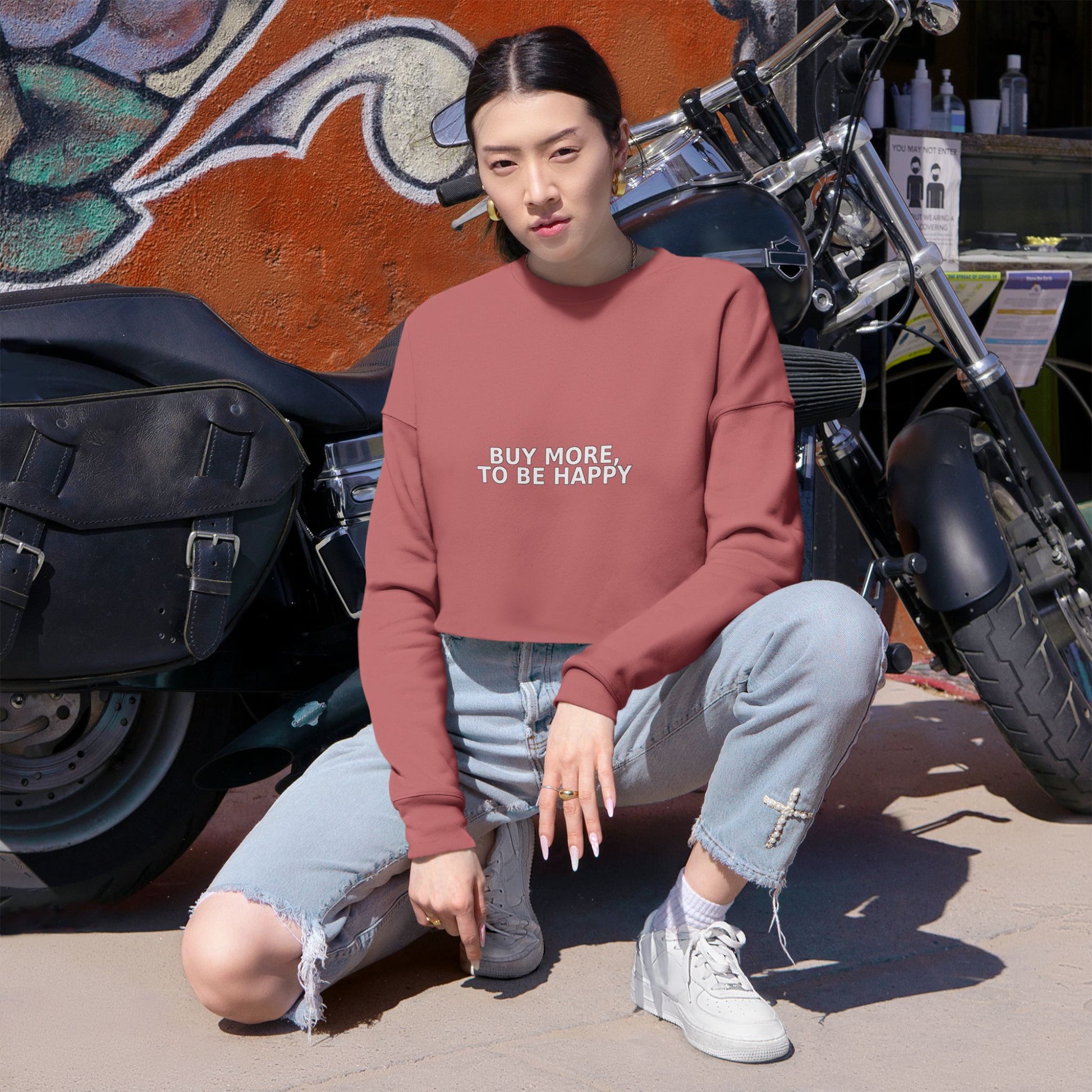 Women’s cropped sweatshirt with a straight silhouette, raw-edge hem, and soft ribbed cuffs on a hanger.      
