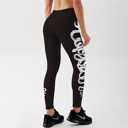 "Black yoga leggings with white coiled snake artwork wrapping leg, mid waist stretchy sportswear for studio sessions"