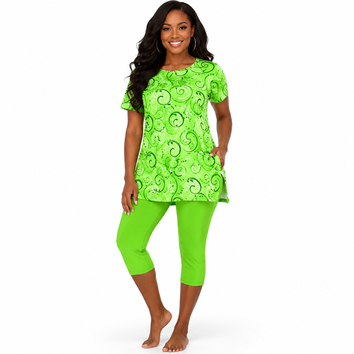 A woman modeling a bright lime green short-sleeve tunic top with a darker green swirl pattern, paired with matching lime green capri leggings, against a plain white background.
