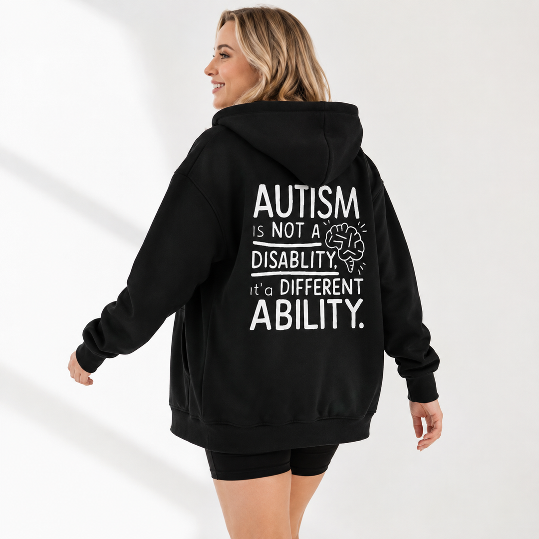 Autism awareness hoodie in Jet Black shown on an adult model in a natural movement pose with the back statement design visible.