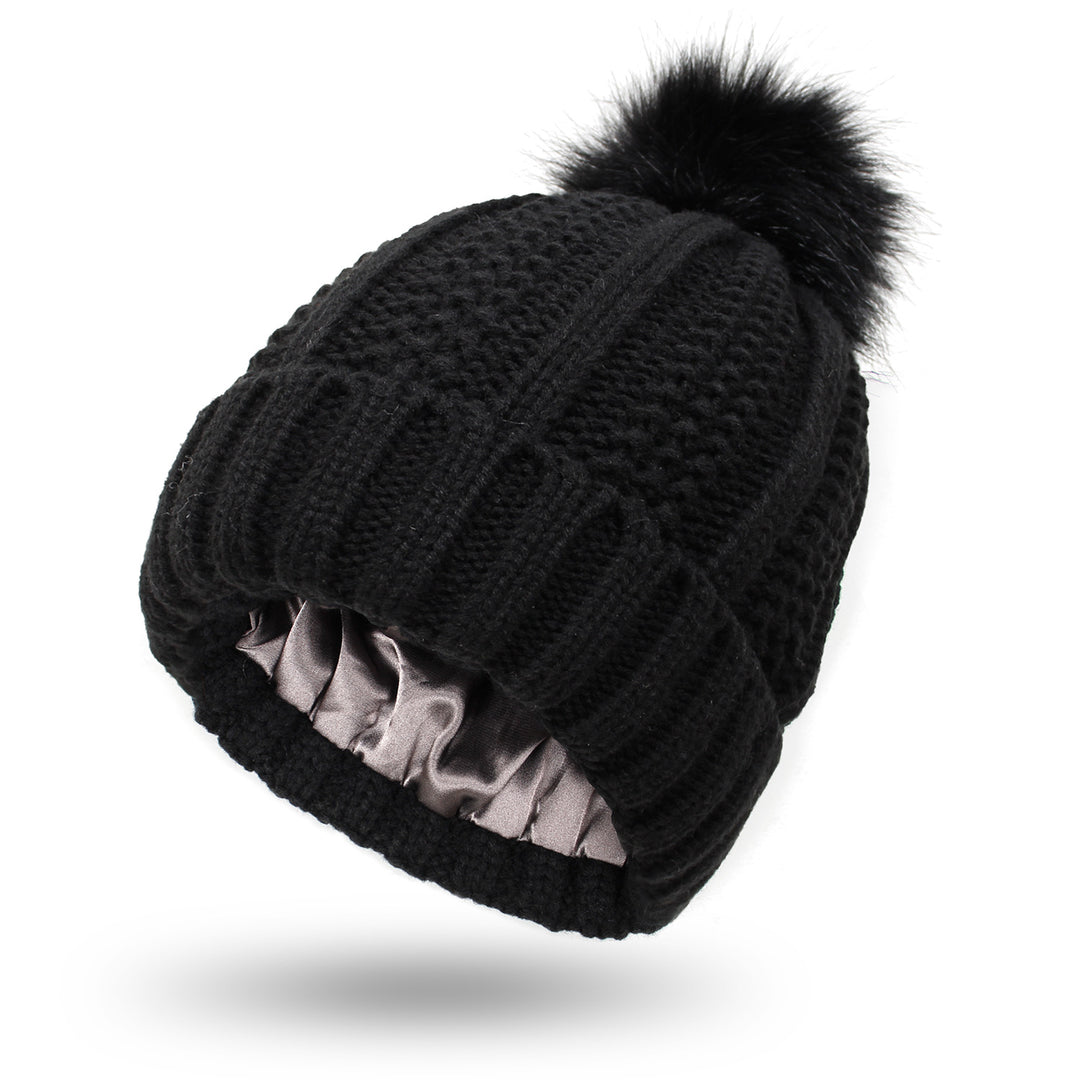 Dark gray satin lined knit beanie with plush pom pom detail, hair friendly interior to reduce frizz after long cold days