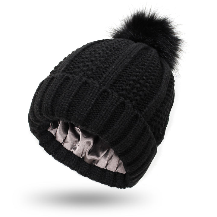 Dark gray satin lined knit beanie with plush pom pom detail, hair friendly interior to reduce frizz after long cold days