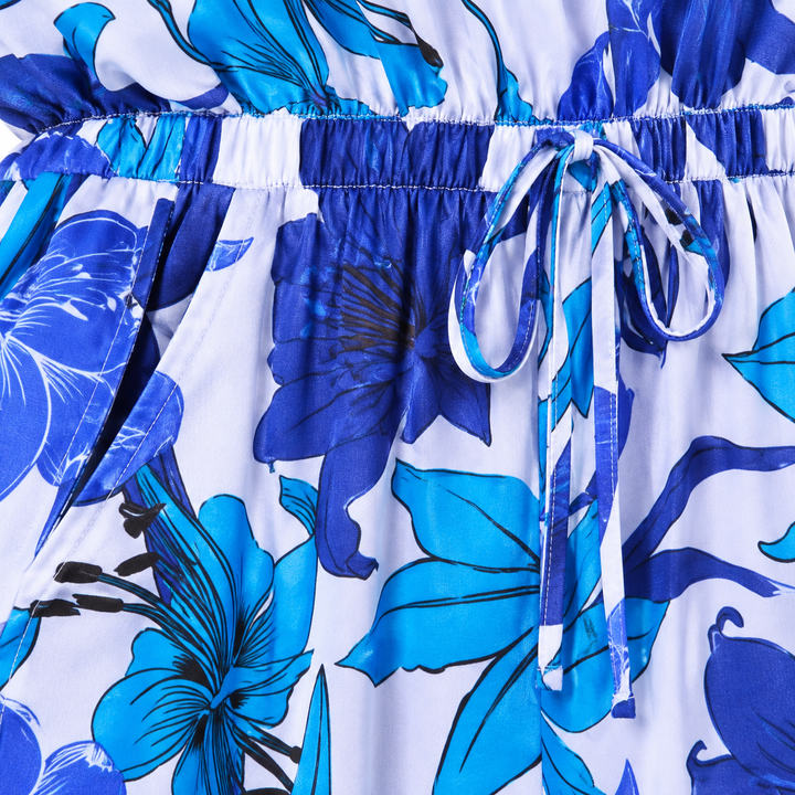 Close-up of the blue floral romper drawstring waist, elastic seam and pocket opening