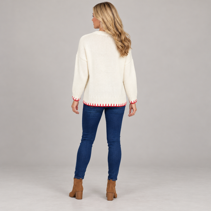 Full-body rear view of the ivory sweater with red stitching at the cuffs and hem.