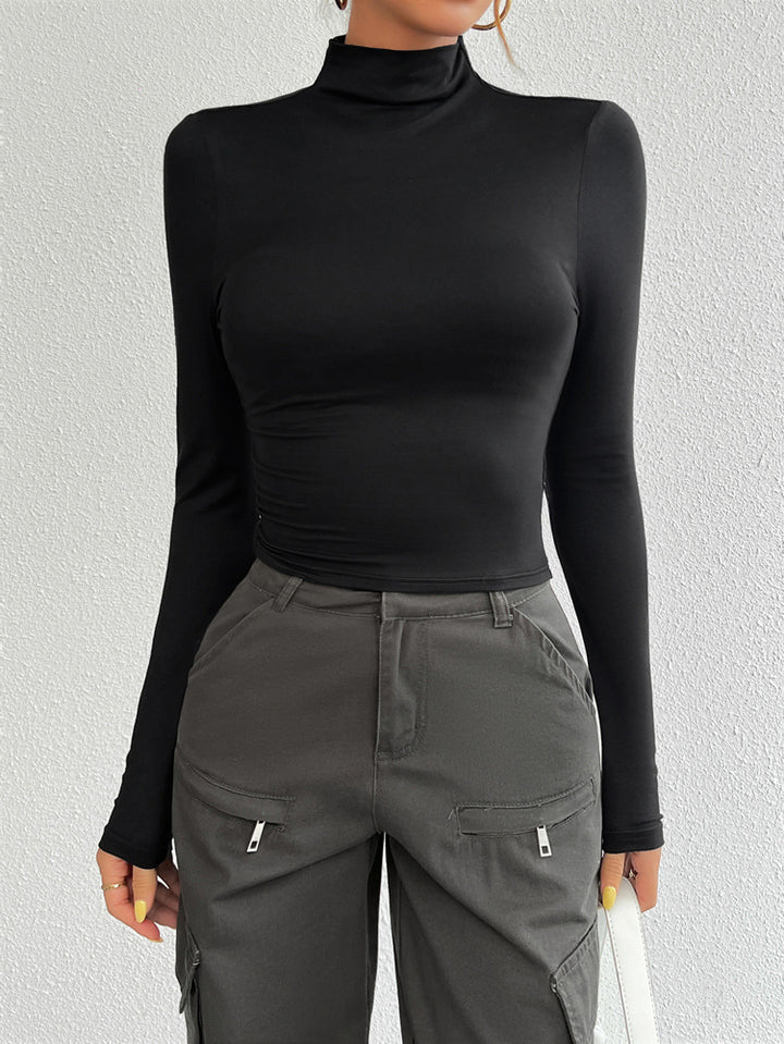 Person wearing a black turtleneck and gray cargo pants against a light gray background