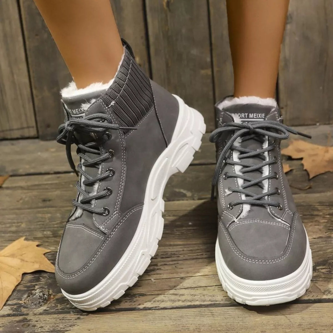 Black plush lined combat boots women laced up with metal hooks close-up