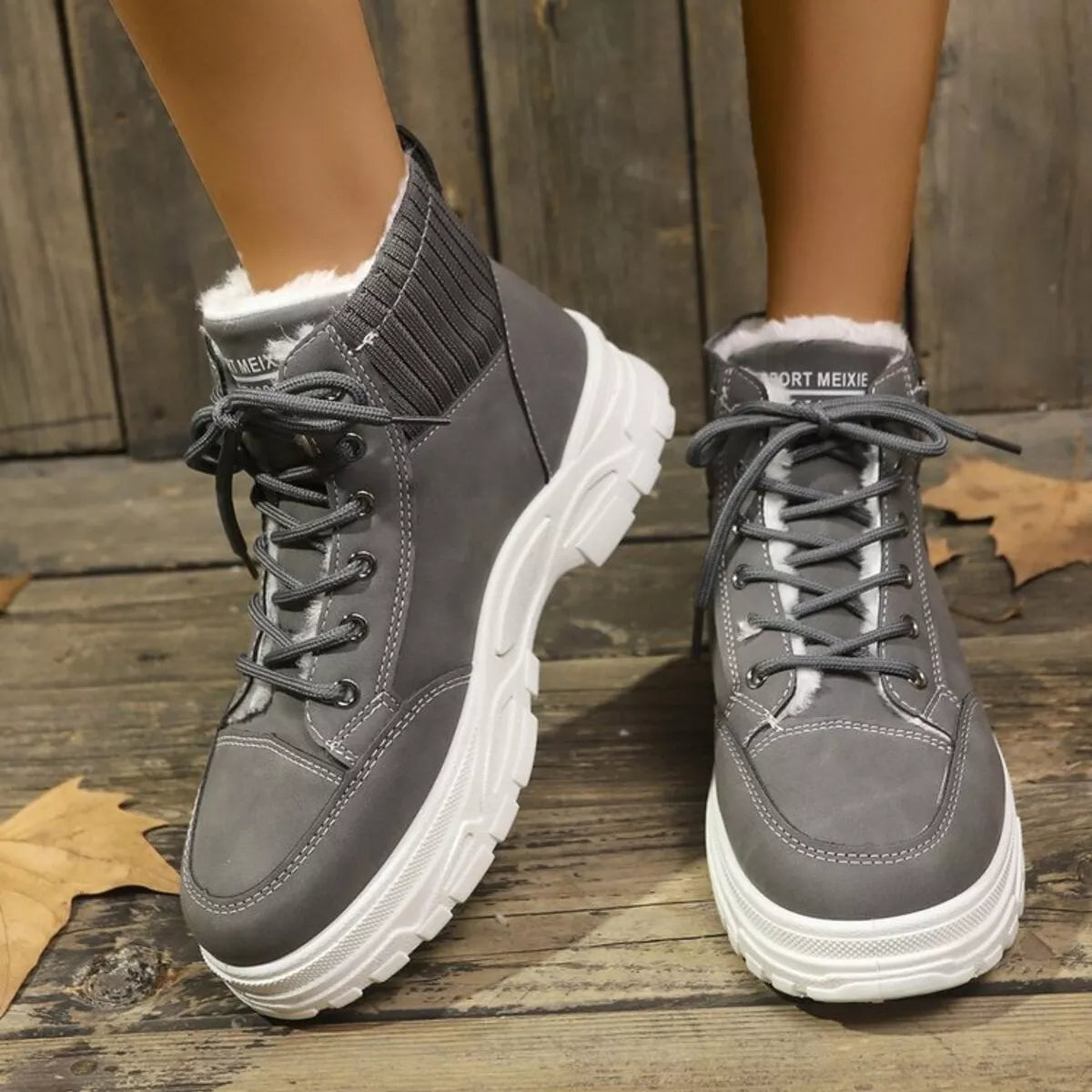 Black plush lined combat boots women laced up with metal hooks close-up