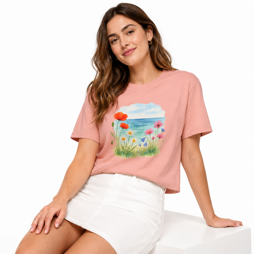 Flat lay of boxy floral t-shirt with folded jeans and simple warm-weather accessories