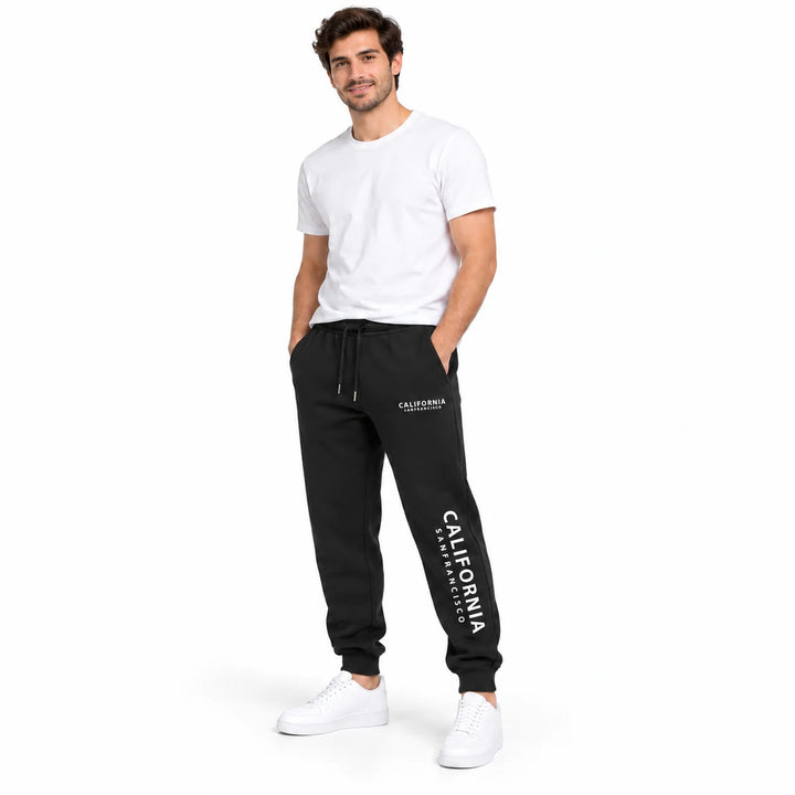 Black California sweatpants worn by an adult male model in a white T-shirt and white sneakers, full length in a white studio.