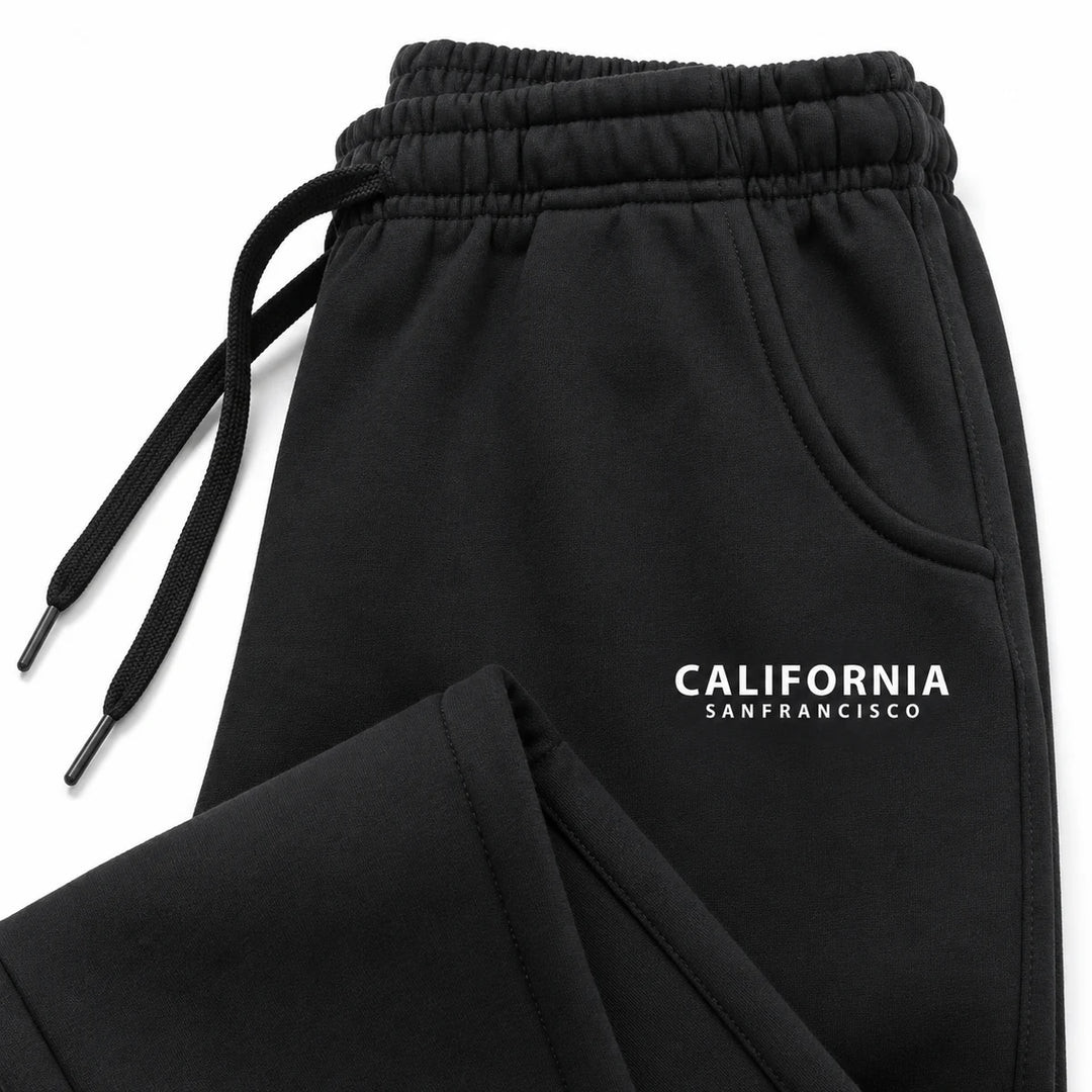Black California sweatpants close-up showing gathered waistband, matching drawstrings, curved pocket hem and white lettering.
