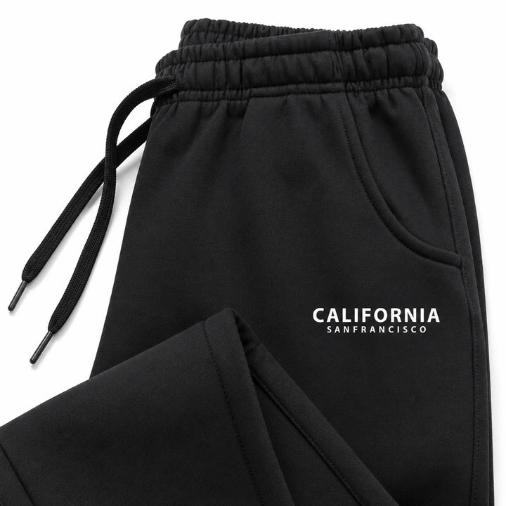 Black California sweatpants close-up showing gathered waistband, matching drawstrings, curved pocket hem and white lettering.