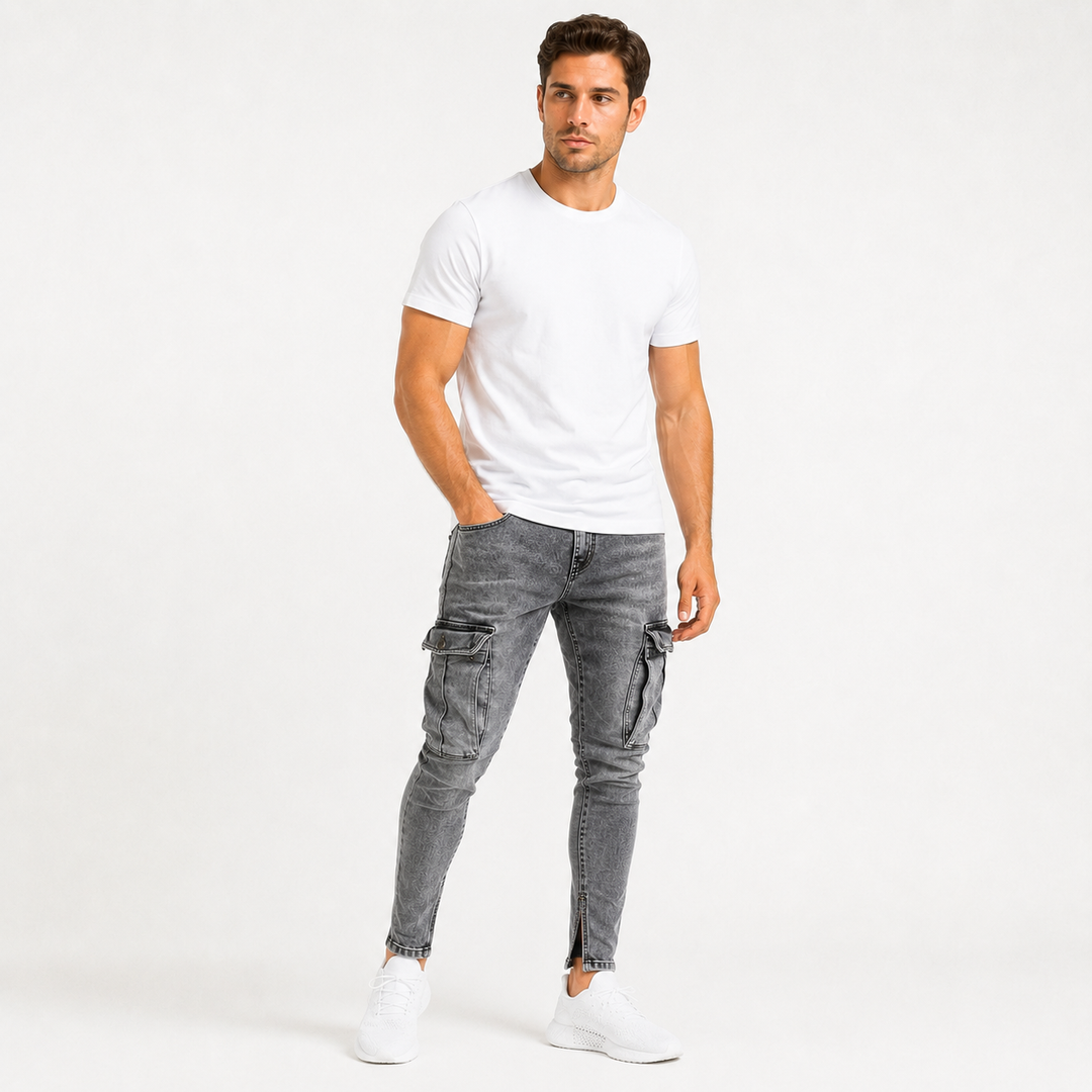 Commercial studio image of washed gray cargo jeans for men on an adult male model with tapered styling and large thigh cargo pockets.