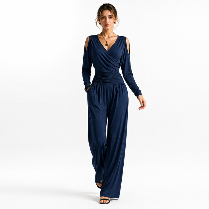 Navy Blue Milk Silk jumpsuit on a woman in a walking pose, highlighting the cold-shoulder sleeves, ruched waist and flowing wide legs.