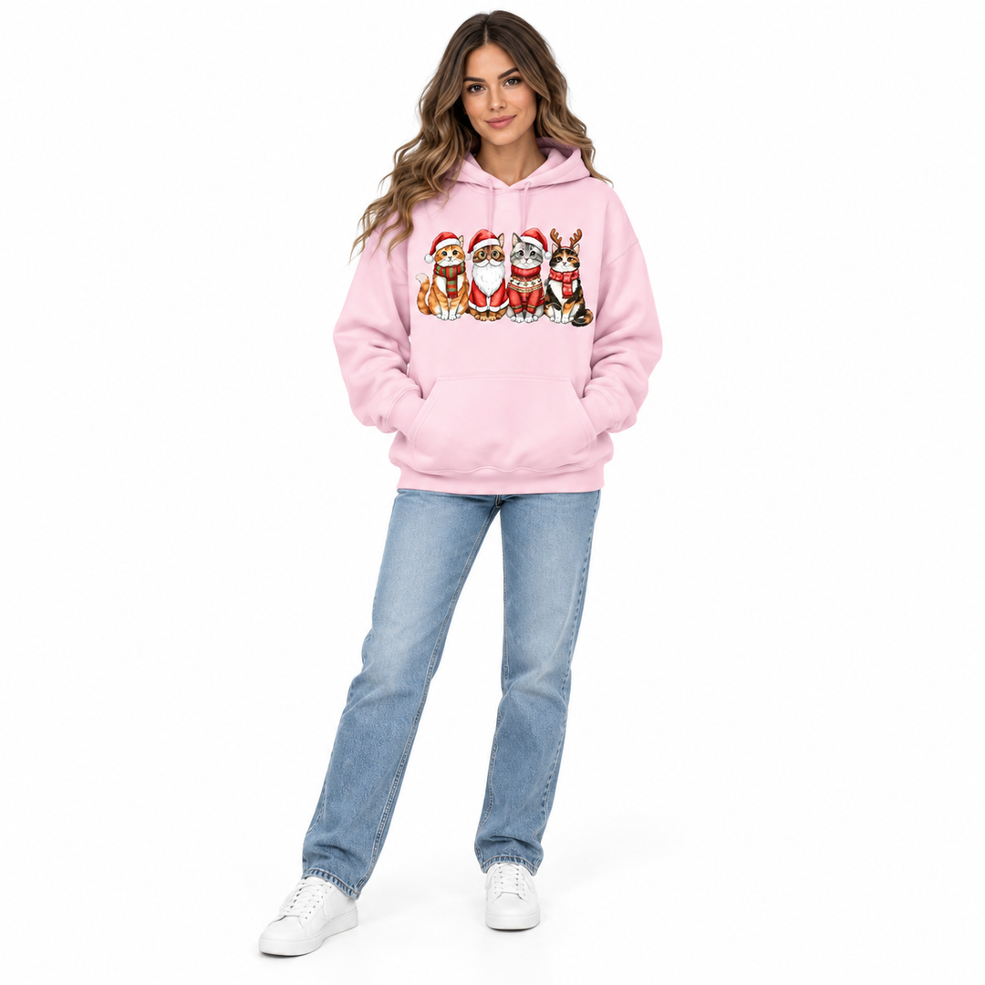 Front view of a woman in a pale pink festive cat hoodie with her hands in the kangaroo pocket.