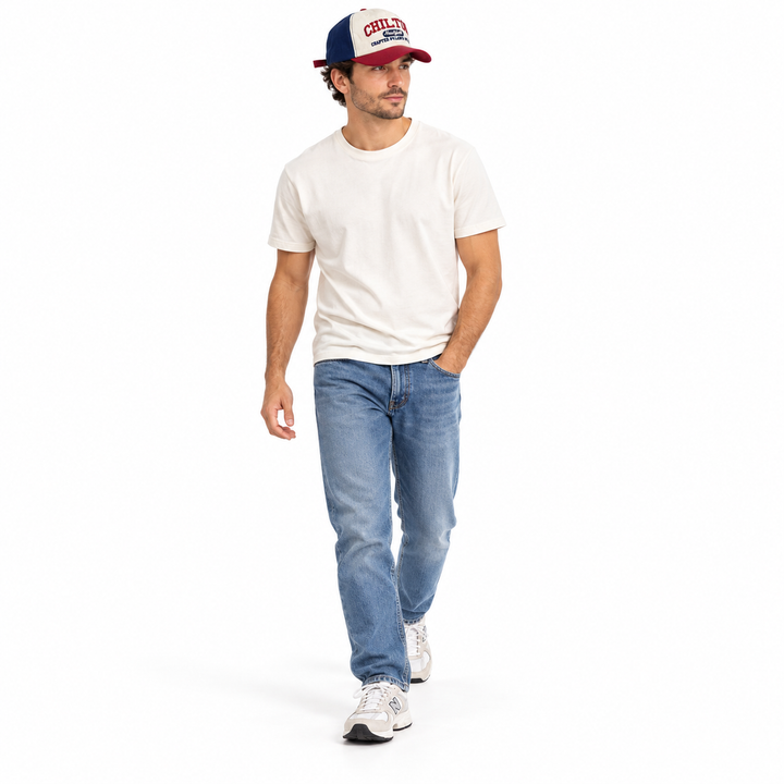 Male model wearing the Navy Blue and Wine Red cap with a white T-shirt and jeans, shown walking against a white studio scene.