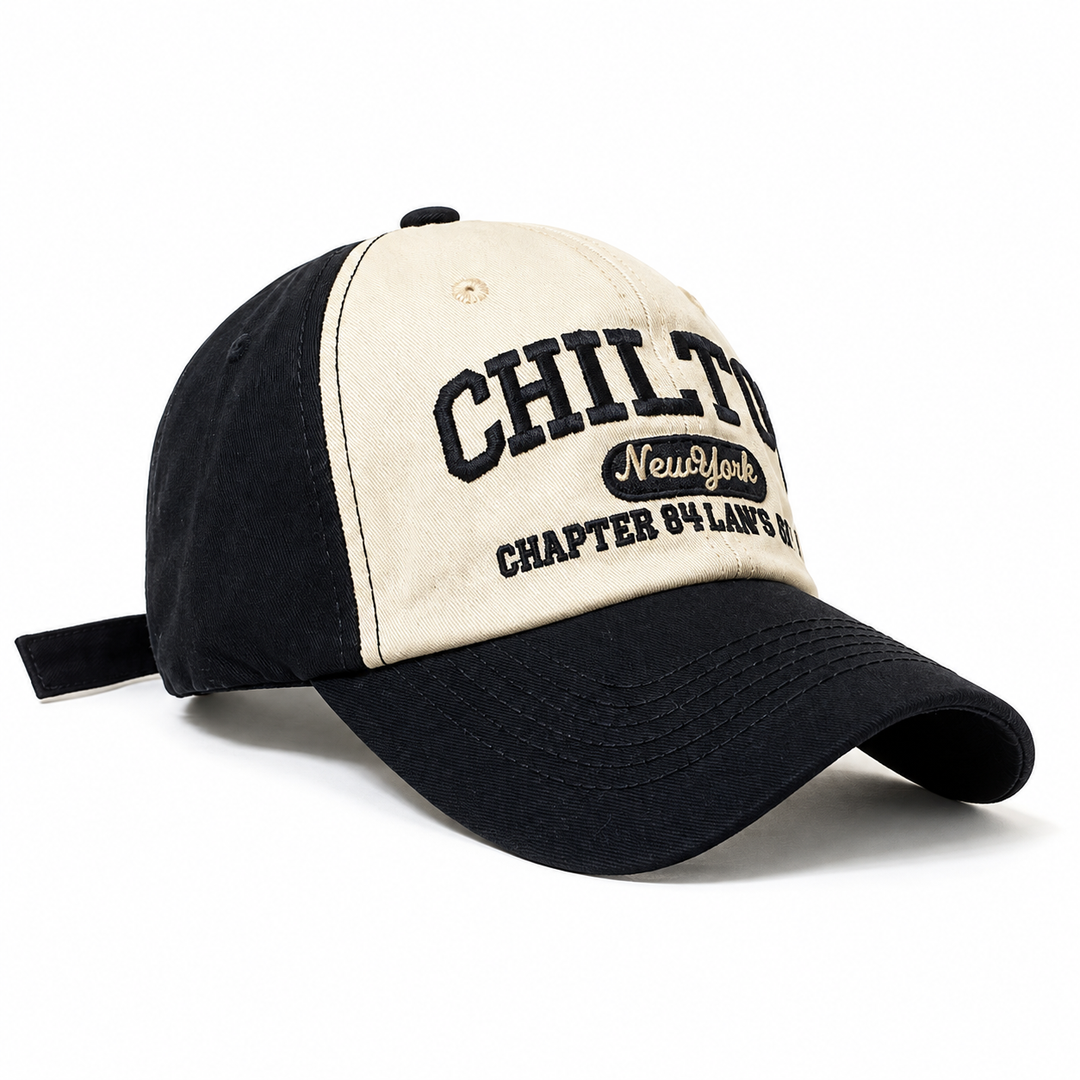 Black embroidered cap in a close three-quarter view showing curved brim, rows of stitches and contrasting cream front panels.