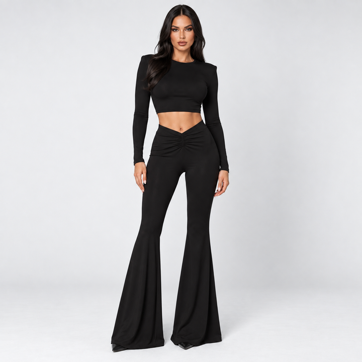 Black crop top and pants set on model in studio front view with long sleeves, ruched V waist and flared trousers