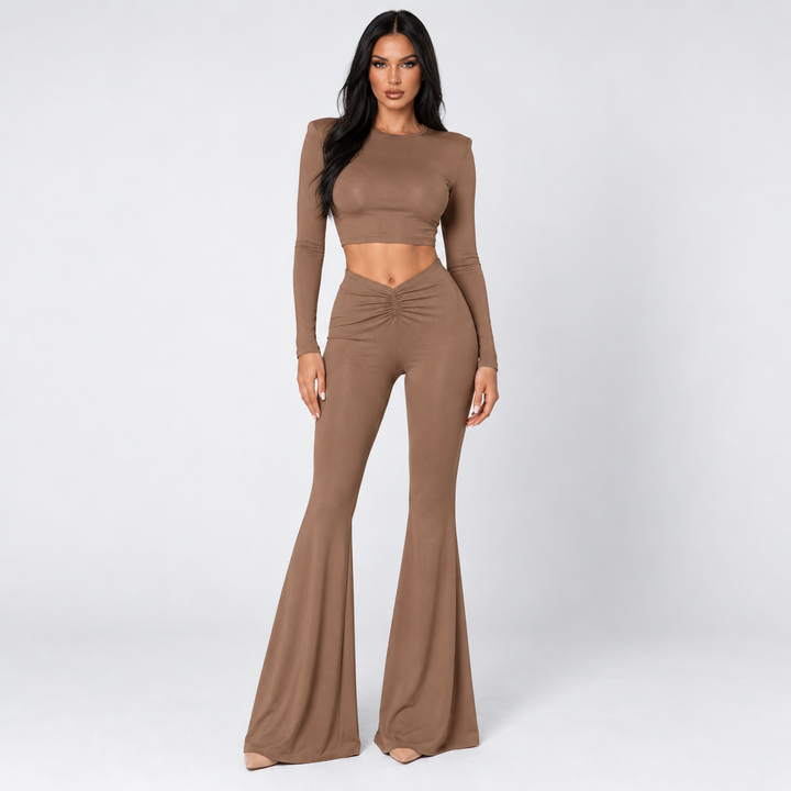 Brown crop top and pants set on model in clean studio front view with long sleeves, ruched waist and flared trousers