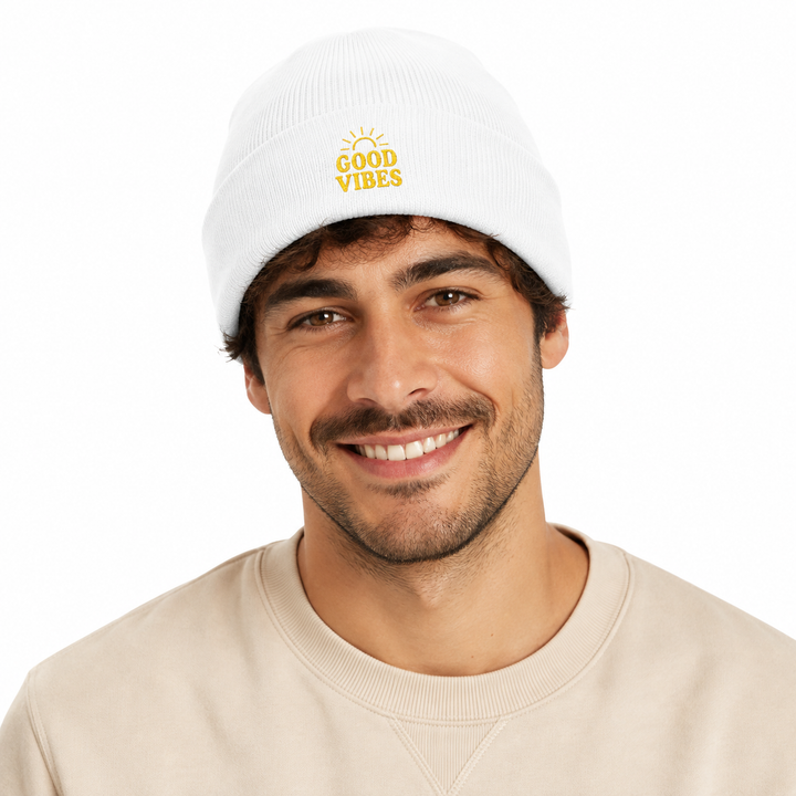 Man wearing white cuffed beanie with embroidered Good Vibes design in a professional white background portrait