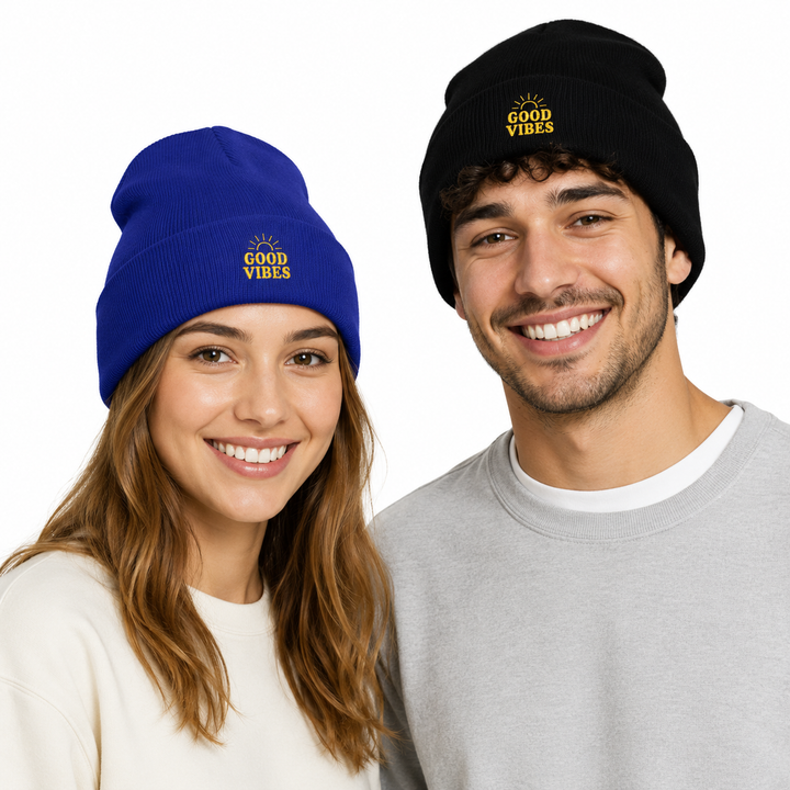 Woman in royal blue cuffed beanie beside man in black cuffed beanie, both with embroidered Good Vibes design