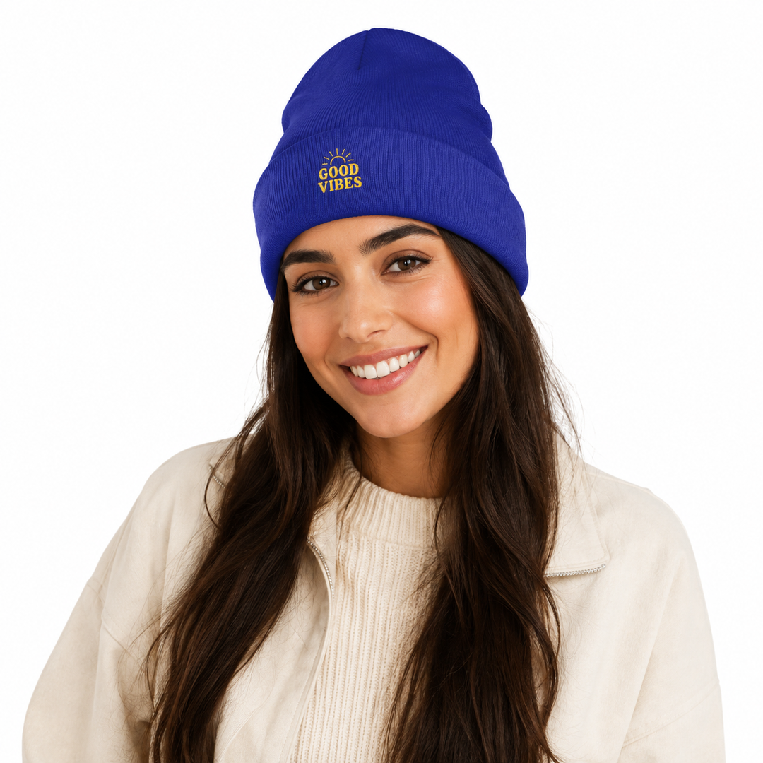Woman wearing royal blue cuffed beanie with embroidered Good Vibes design on white studio background