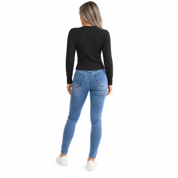 Black sweater rear view shot on a full-length adult model, showing its plain knit back, cable sleeves and ribbed hem on white